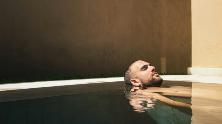 Homme qui se détend dans un bassin au soleil.