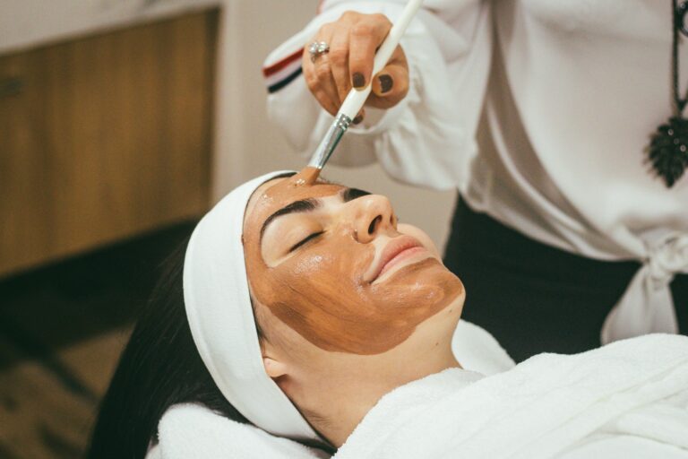 Un professionnel applique un masque facial sur un client.