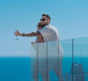 Un couple regarde la mer sur un balcon.